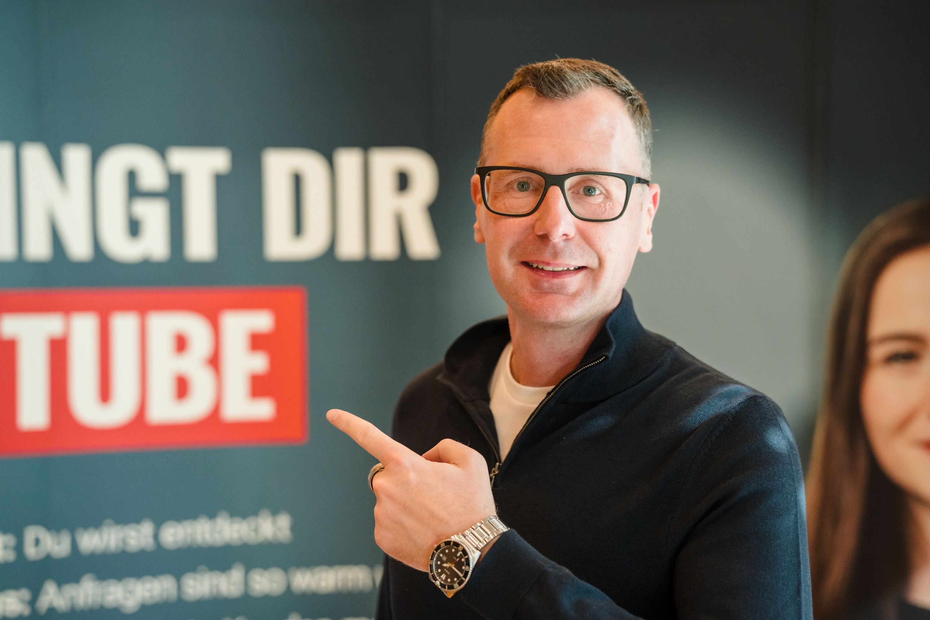 Mario Märzinger zeigt auf ein YouTube-Banner